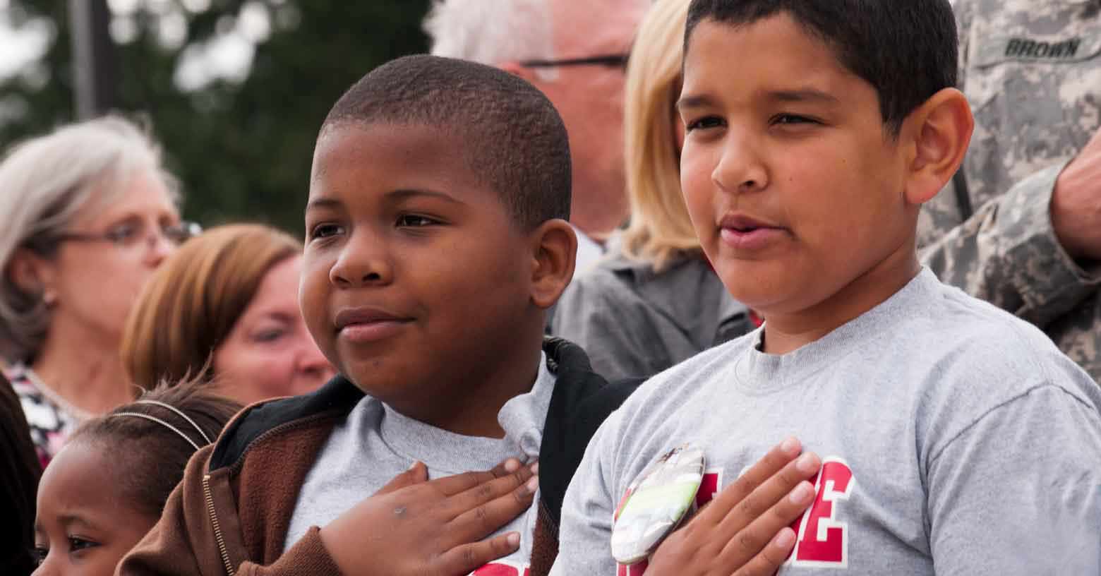 two young boys cite the pledge of allegiance